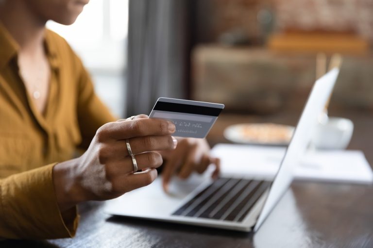 Female,Hand,Holding,Credit,Card,At,Laptop,Close,Up.,Young